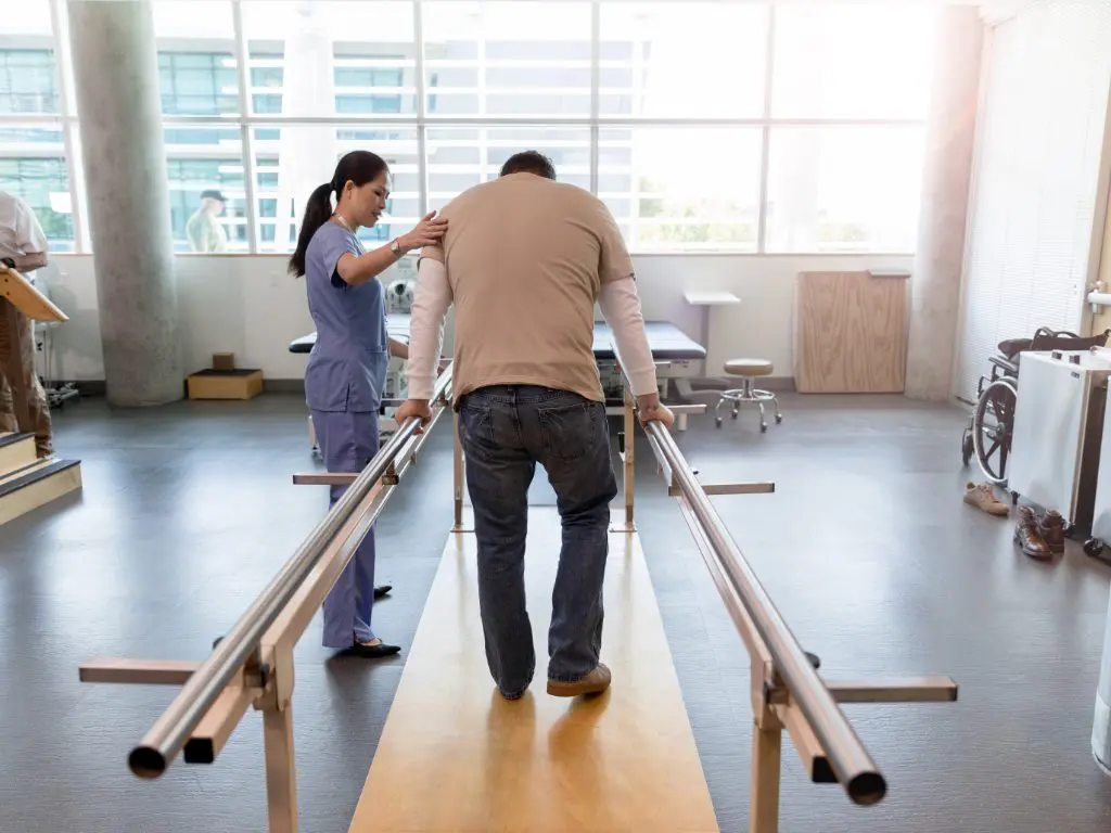 Physical therapist assisting a patient with balance and fall prevention.