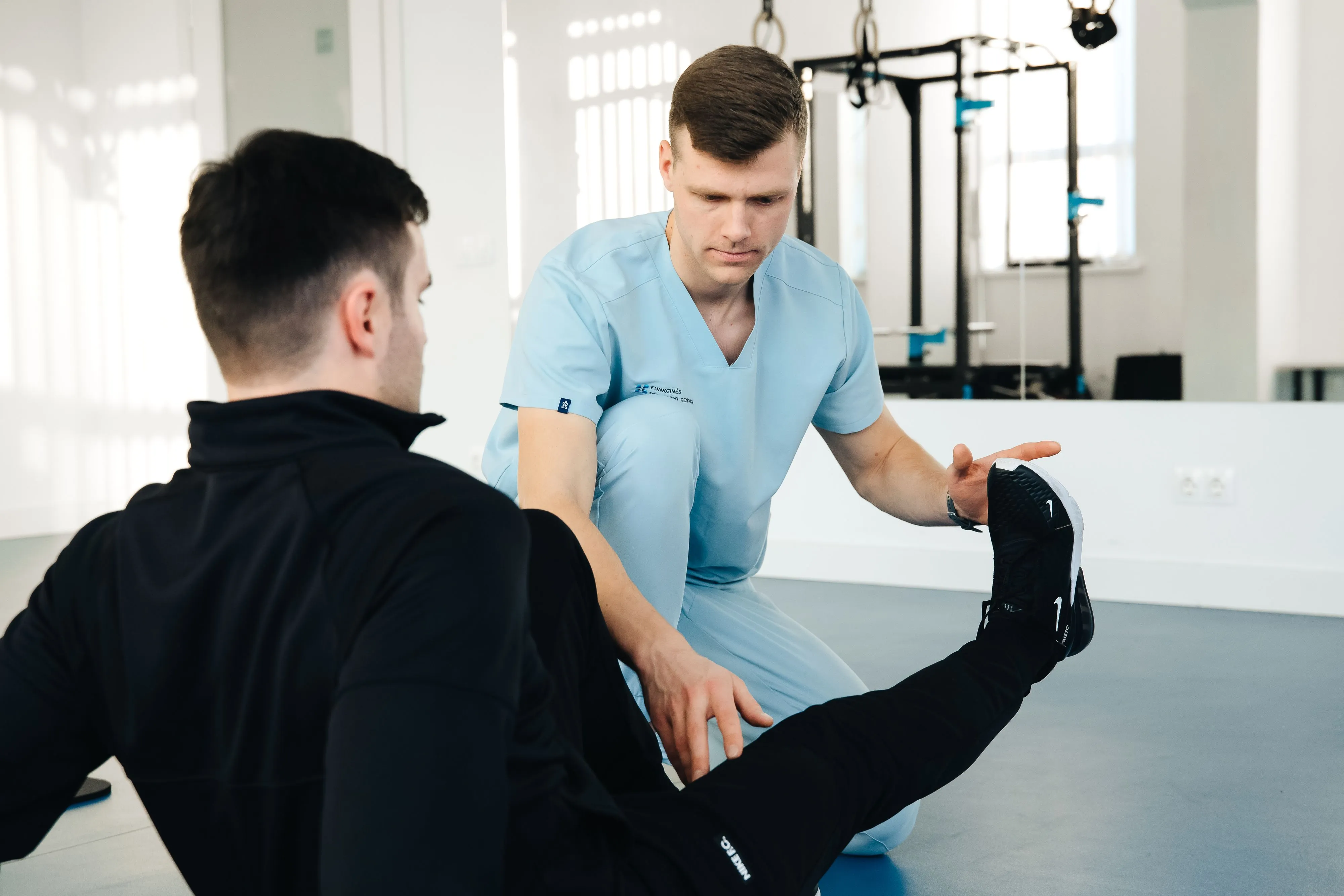 Physical therapist assisting a patient with sports injury rehabilitation.