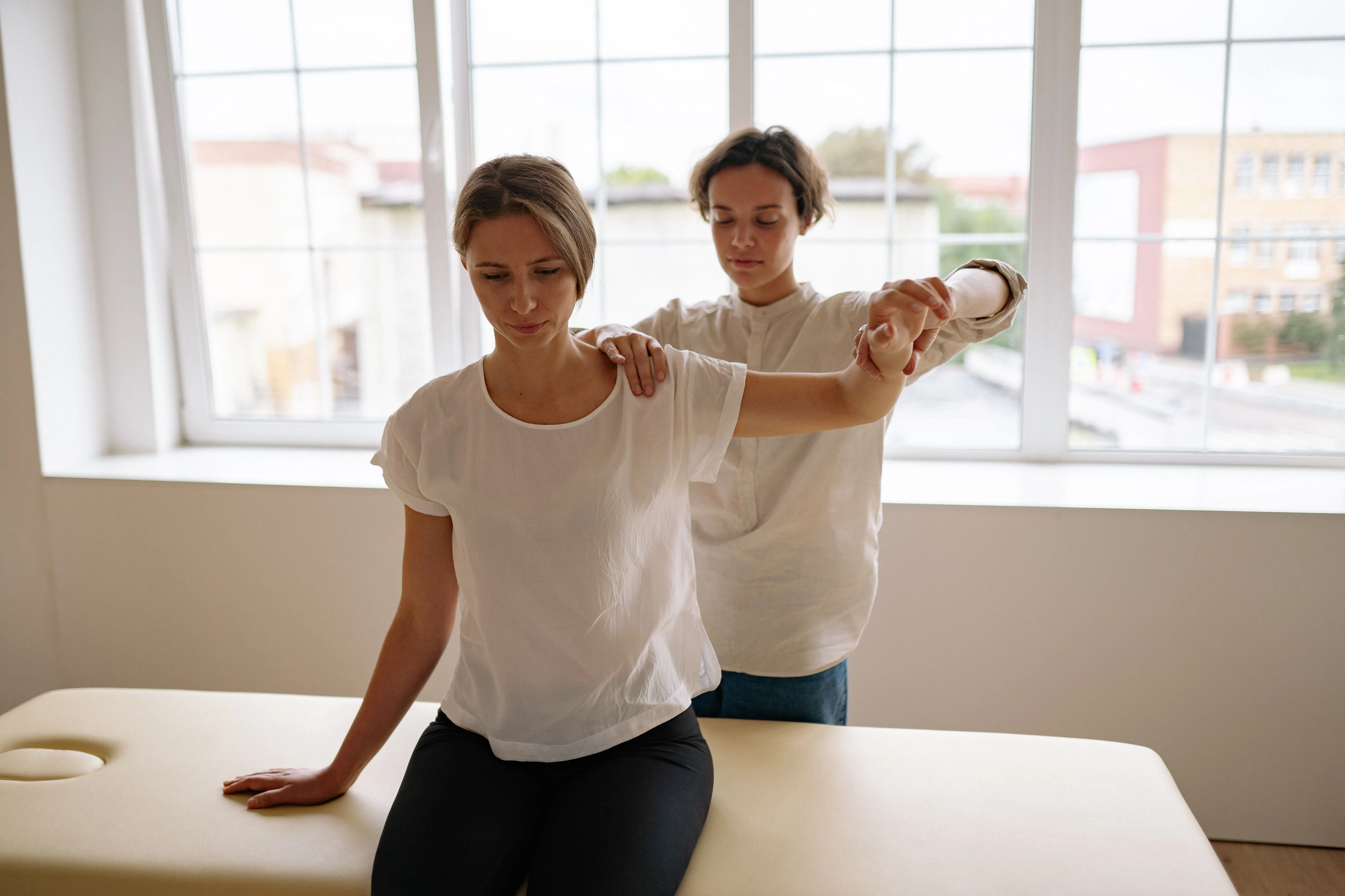 Physical therapist assisting a patient with post-surgical recovery.